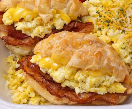 Croissant breakfast sandwiches loaded with bacon, eggs, strawberries